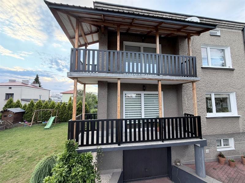 Czarne balustrady pionowe na dwóch tarasach domu